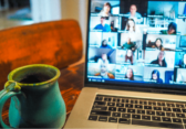 Mug sitting on desk next to laptop with Zoom conference on screen