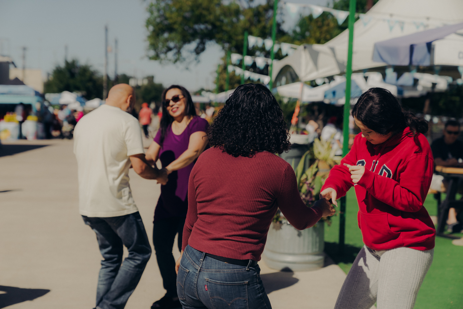 Attendees dance in the sunshine at a Latin City event.