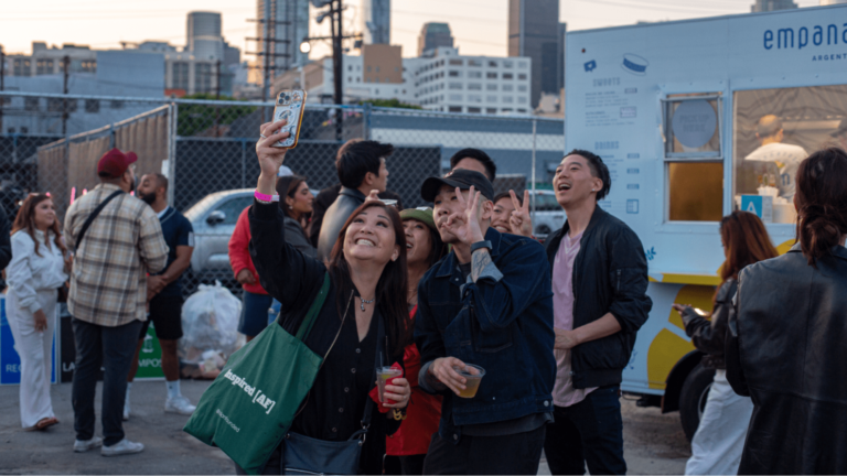 People taking selfies at a food truck event.